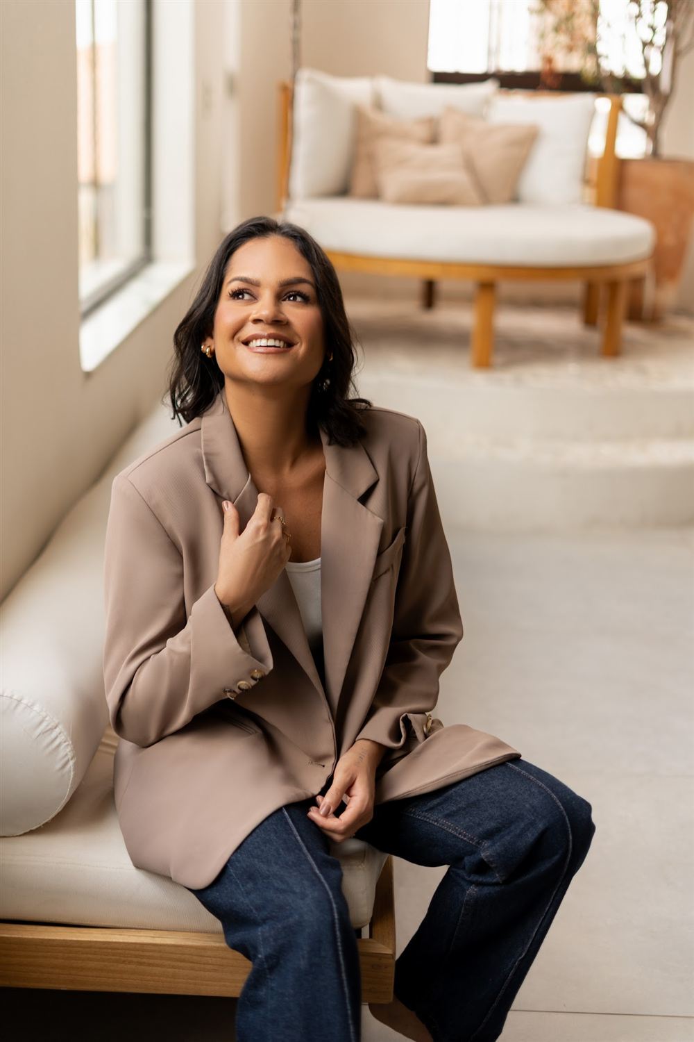 Dra. Natália Itaiá sentada em ambiente claro, sorrindo